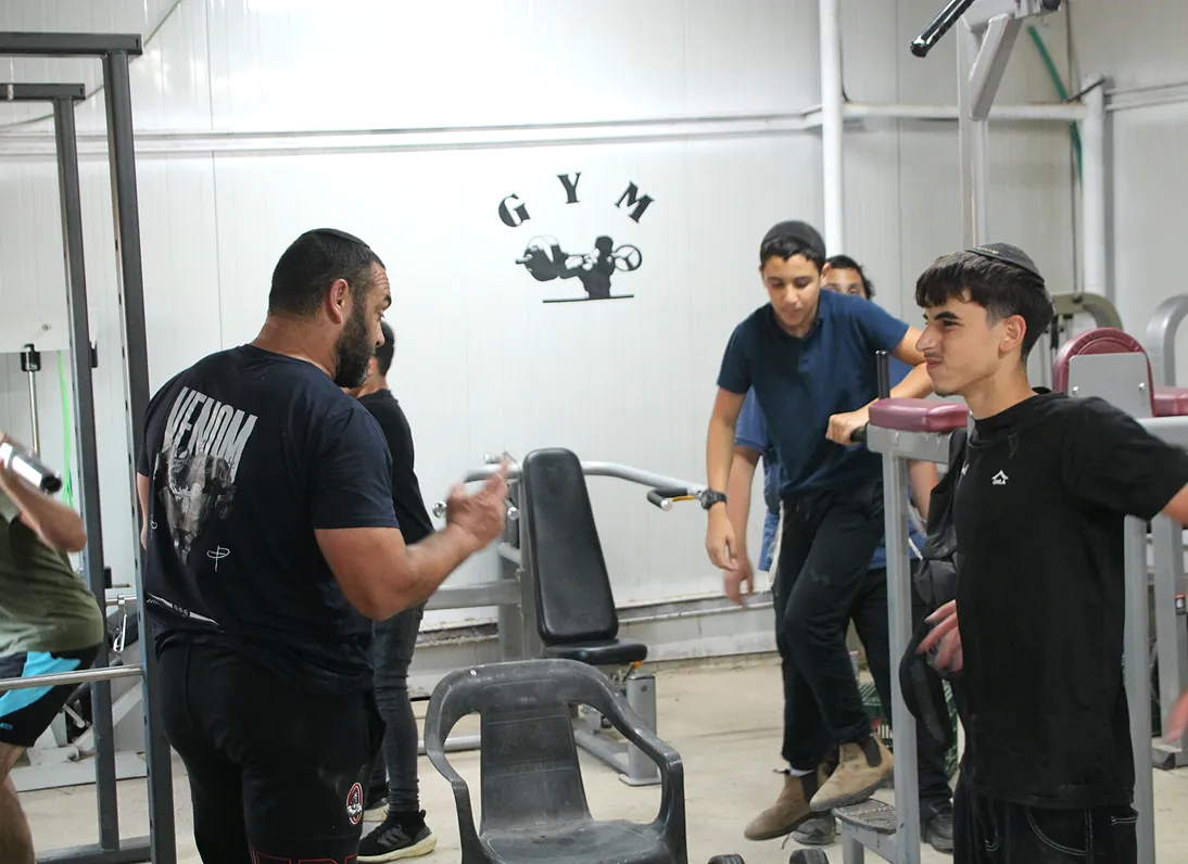 המאמן עם הבחורים בחדר הכושר