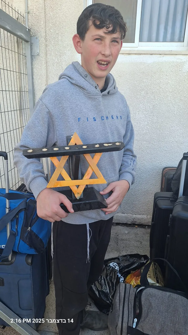 תלמיד מחזיק חנוכייה מעץ עם מגן דוד - מבצע חנוכה בבית המדרש