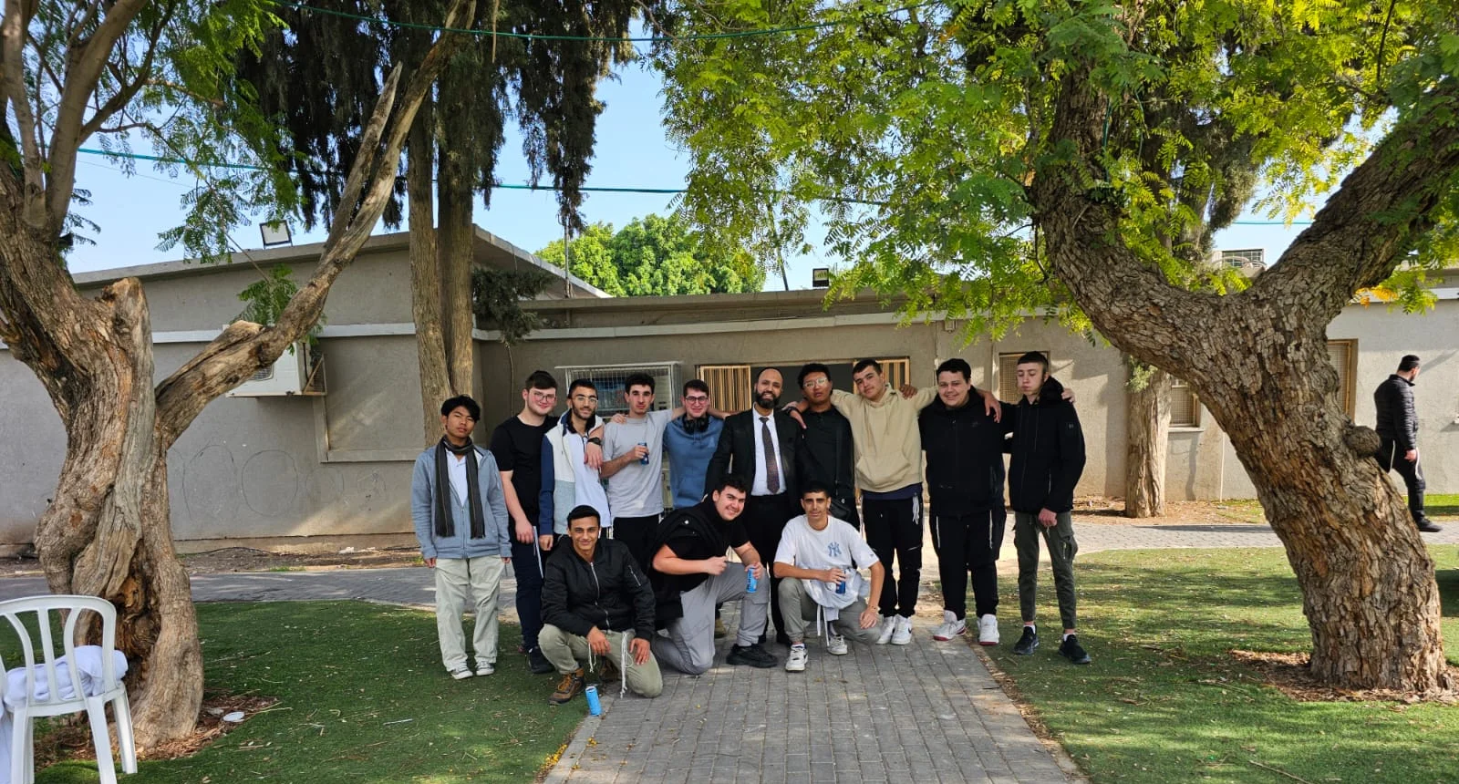 קבוצת תלמידים בחצר בין עצים - ביליארד בבית שאן