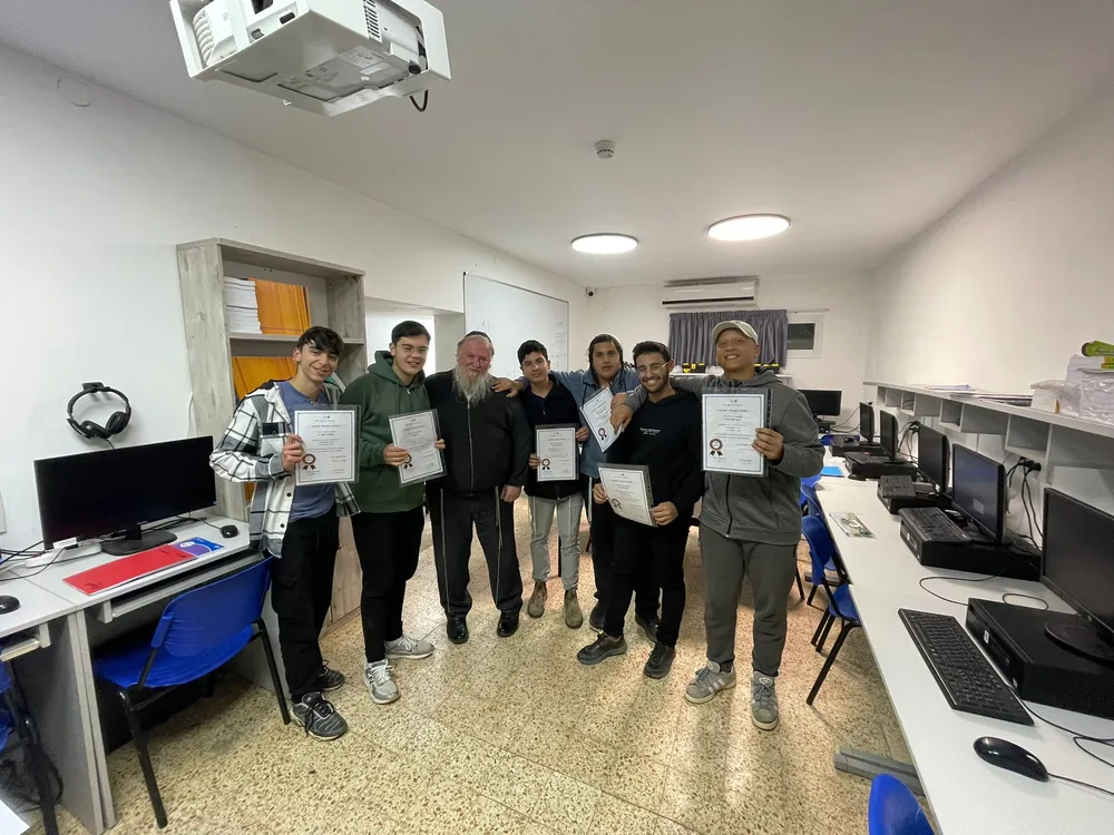 צילום רחב של תלמידים מציגים תעודות בחדר מחשבים - תעודות המחצית, ואחריהן מסיבה