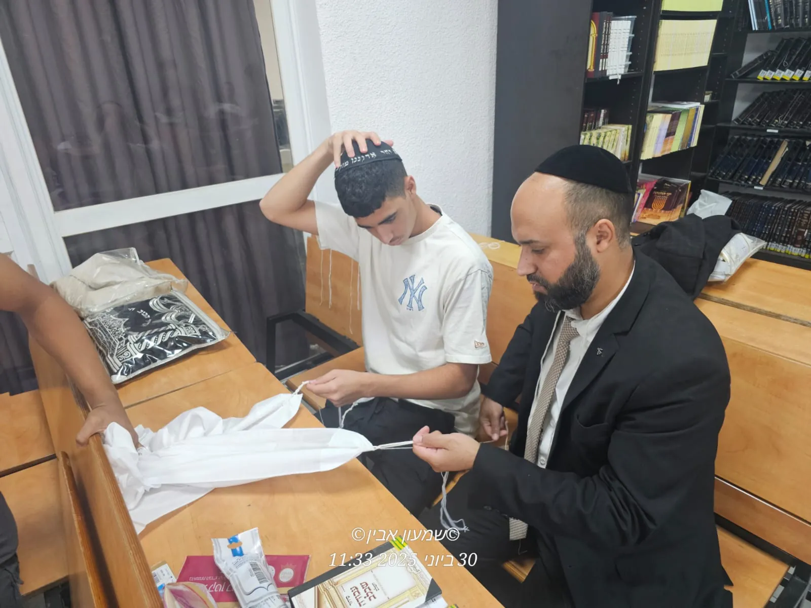 רב ותלמיד מכינים ציציות יחד - סדנת הכנת ציציות בבית המדרש