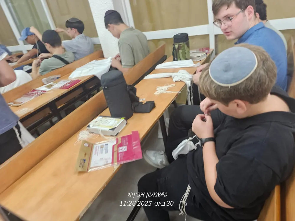 תלמידים עובדים על ציציות בשולחנות בית המדרש - סדנת הכנת ציציות בבית המדרש