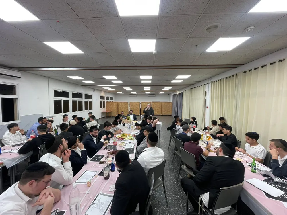 צילום רחב של סעודת טו בשבט סביב שולחנות עם פירות - סעודת ט״ו בשבט