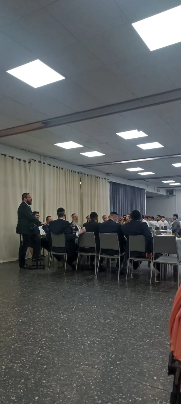 איש צוות מדבר בפני משתתפי ארוחת סיום כיתה יב - ערב הסיום של מחזור י״ב