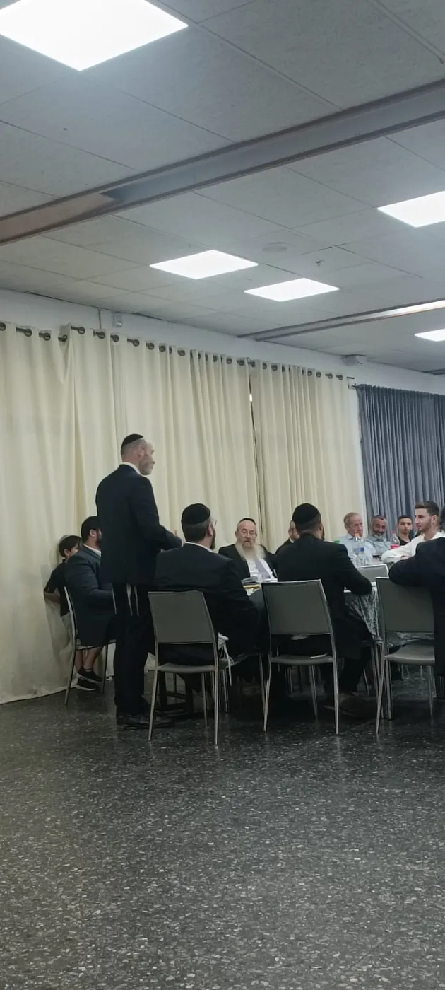 משתתפים יושבים סביב שולחן בארוחת סיום כיתה יב - ערב הסיום של מחזור י״ב
