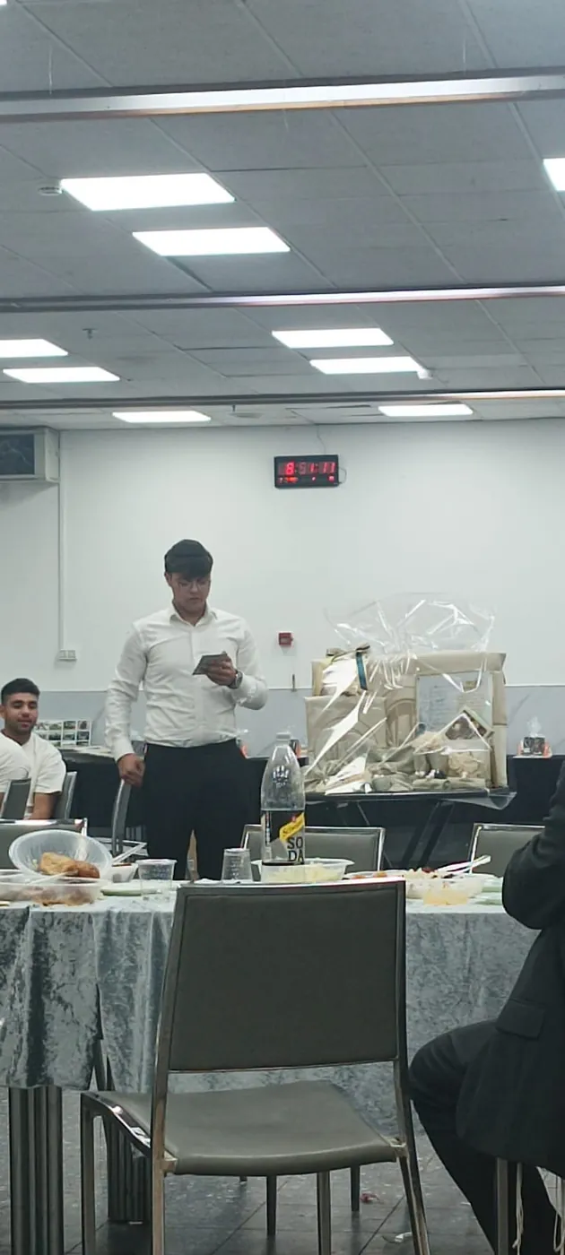 תלמיד מדבר בארוחת סיום כיתה יב - ערב הסיום של מחזור י״ב