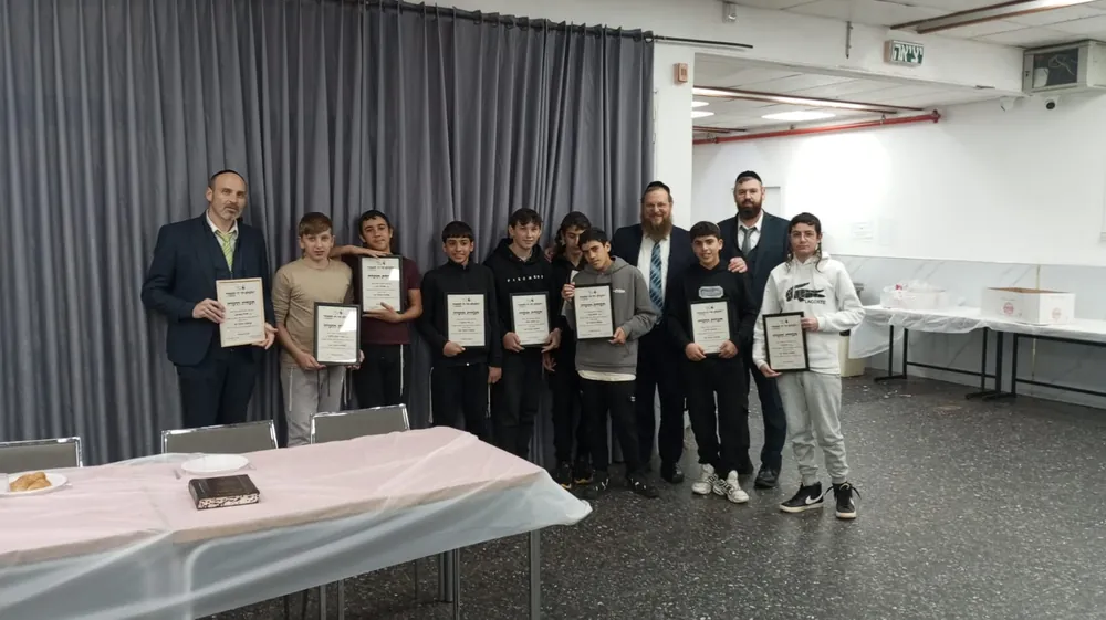 קבוצת תלמידים אחרת מציגה תעודות עם אנשי צוות - סיום מסכת - תעודה ביד וסעודה משותפת