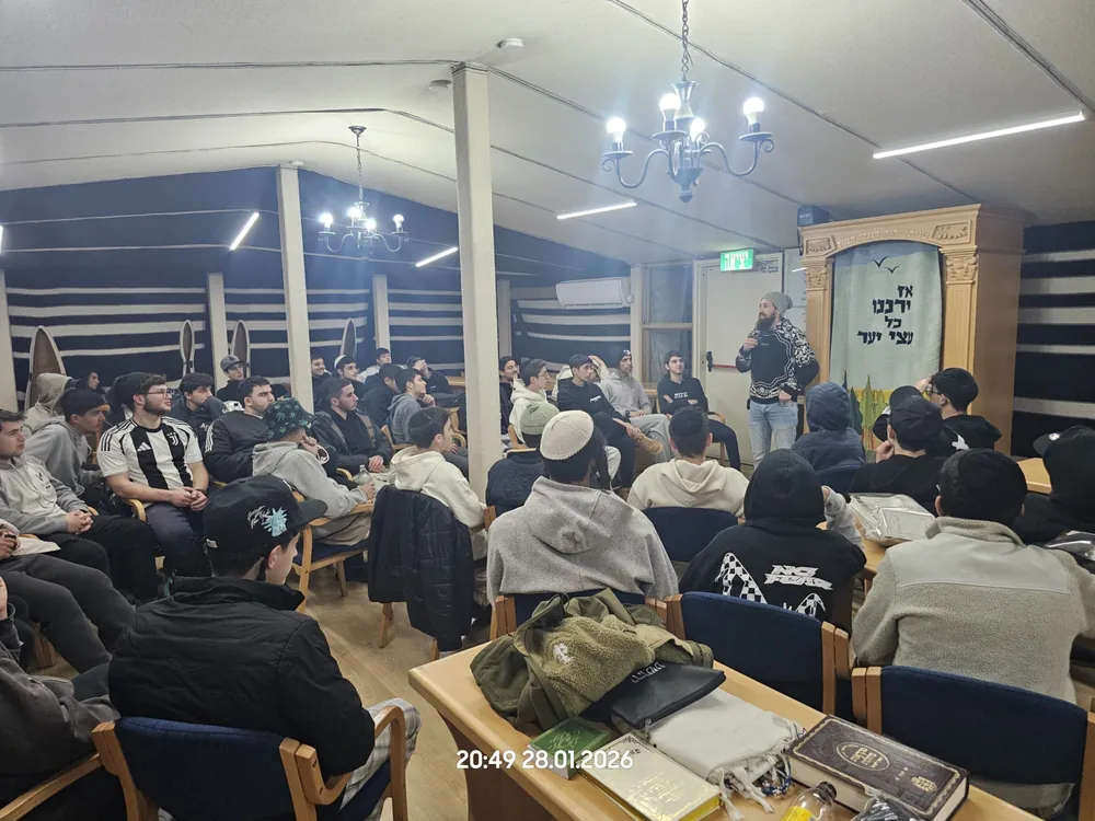 טיול שנתי - דובר בסווטשרט כהה מול תלמידים באולם - הטיול השנתי: יומיים בנגב