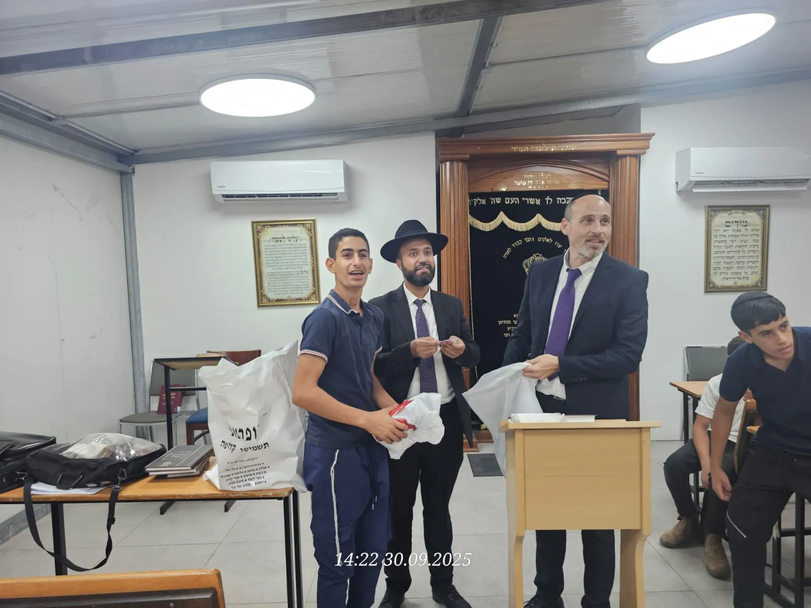 תלמיד מצטלם עם שי לצד שני רבנים - ימים נוראים בישיבה, וסיום מסכת שסגר את תשרי