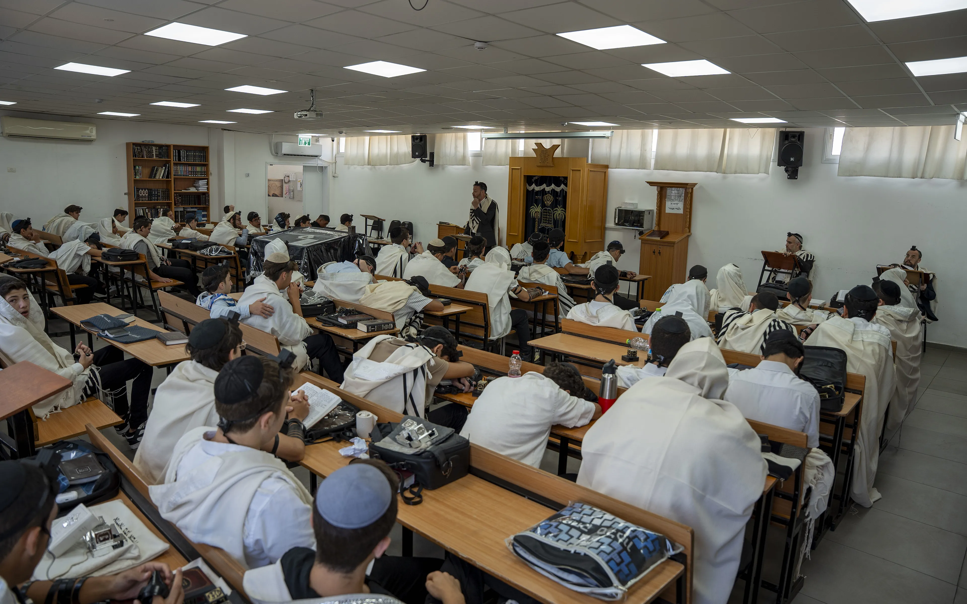 תלמידים עטופים בטליתות בתפילת שחרית בבית המדרש של זיו אור נתניה